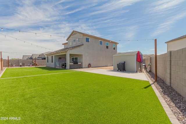 back of property featuring a shed, a lawn, and a patio area