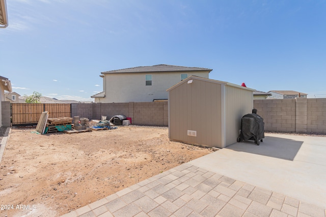 view of yard with a storage shed and a patio