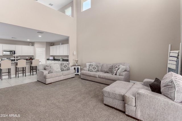 living room with light carpet and a high ceiling