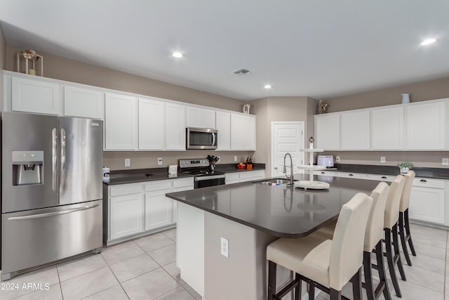 kitchen featuring white cabinetry, appliances with stainless steel finishes, a kitchen island with sink, and sink