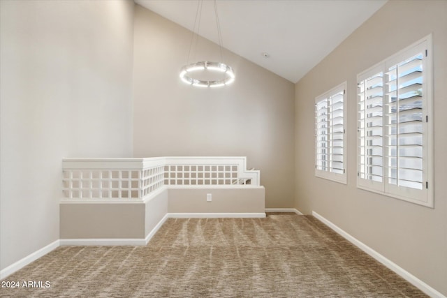 spare room featuring carpet floors and high vaulted ceiling