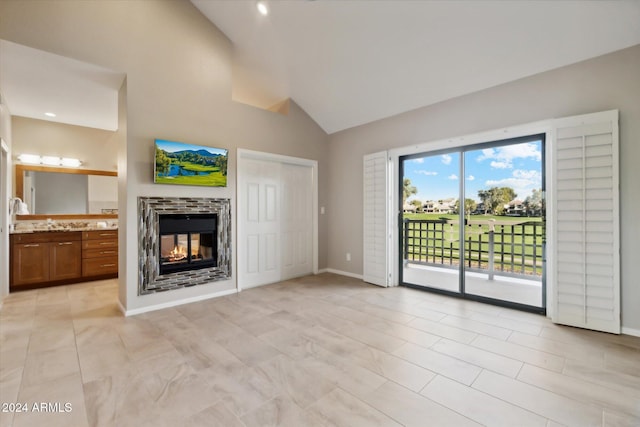 unfurnished living room featuring a multi sided fireplace and high vaulted ceiling