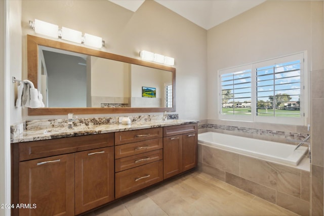 bathroom with vanity, tile patterned flooring, and a relaxing tiled tub