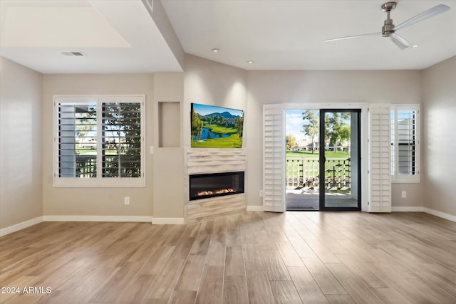 unfurnished living room featuring ceiling fan, a high end fireplace, and light wood-type flooring