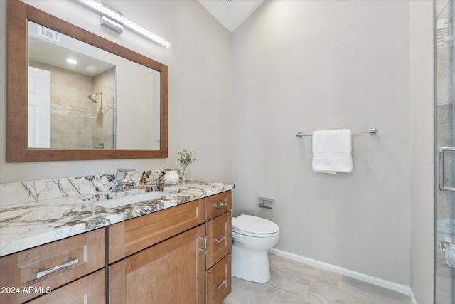 bathroom featuring tile patterned flooring, vanity, toilet, and a shower with door