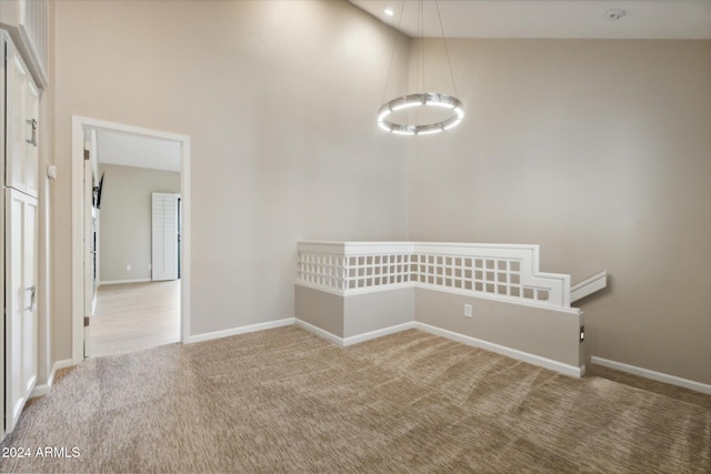 empty room featuring light colored carpet and high vaulted ceiling