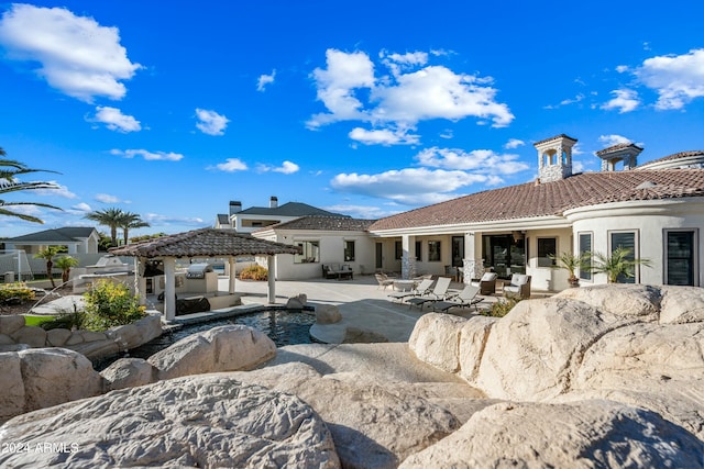 back of property featuring a gazebo and a patio