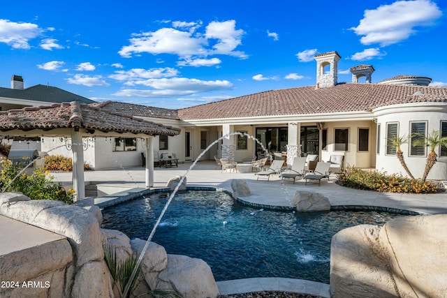 view of pool featuring pool water feature, a patio, and a grill