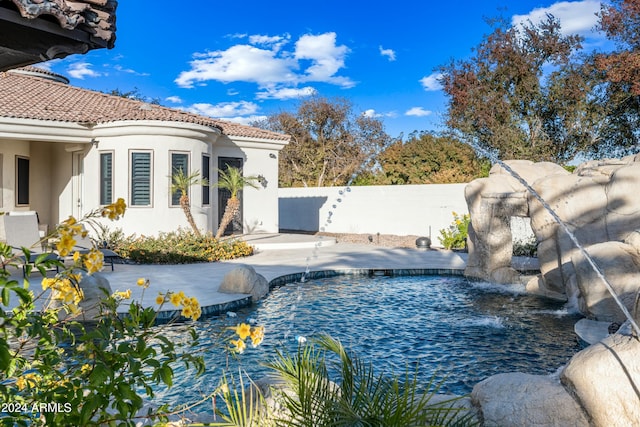 view of swimming pool with pool water feature and a patio area