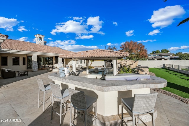 view of patio with exterior kitchen and an outdoor bar