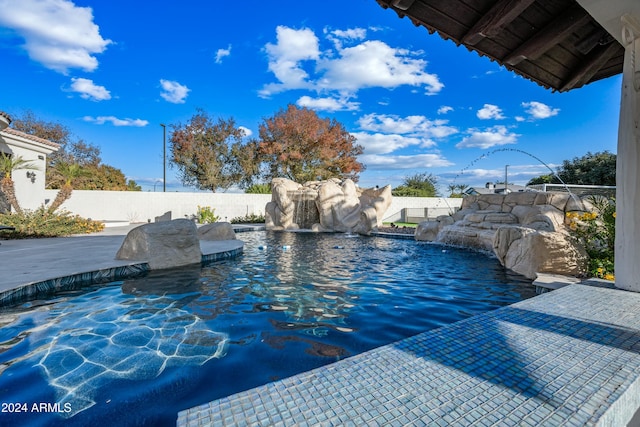 view of swimming pool with pool water feature