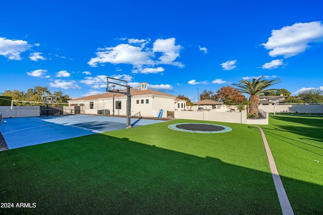 exterior space featuring basketball court, cooling unit, and a lawn