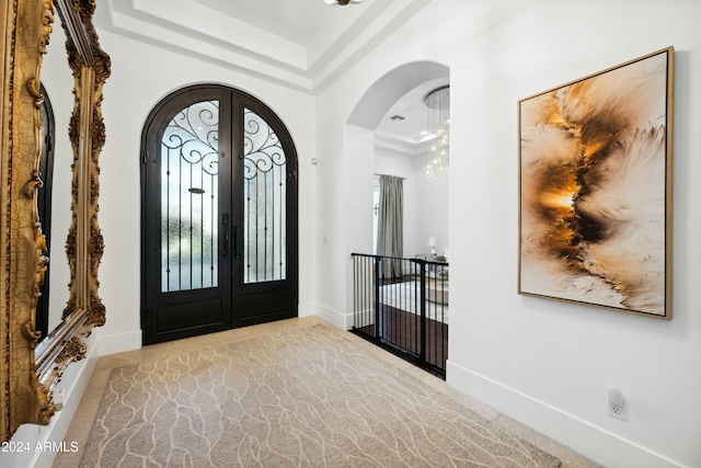 entrance foyer featuring a raised ceiling and french doors