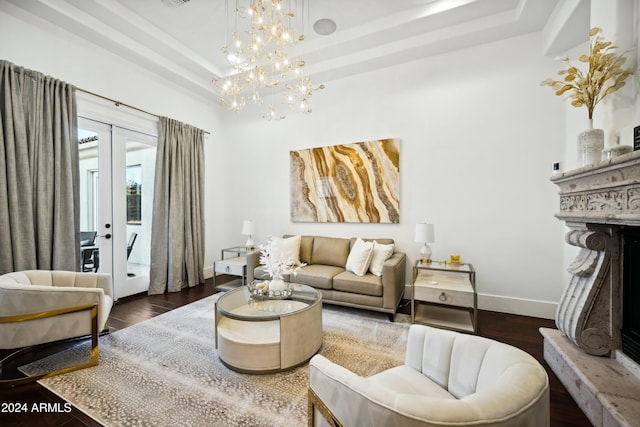 living room with french doors, dark hardwood / wood-style flooring, a tray ceiling, and an inviting chandelier