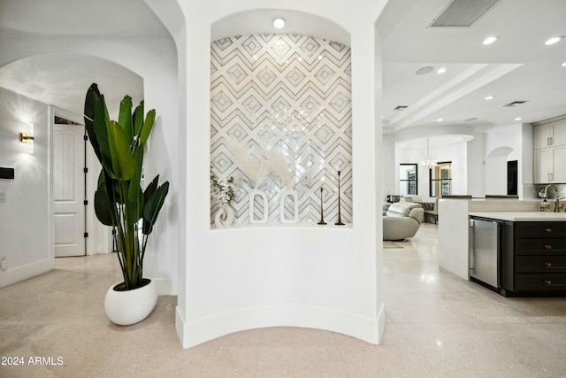 hallway featuring tile walls and a notable chandelier