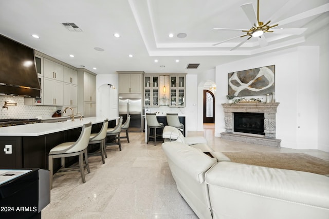 living room featuring ceiling fan and a tray ceiling