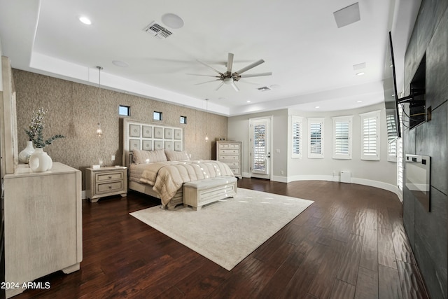 bedroom featuring a tray ceiling, ceiling fan, and dark wood-type flooring