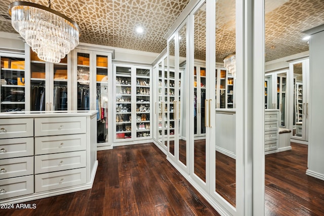 walk in closet with dark hardwood / wood-style floors and a notable chandelier