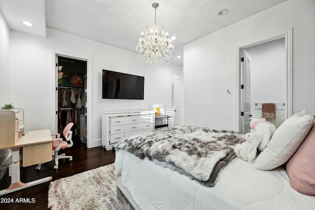 bedroom with an inviting chandelier, dark hardwood / wood-style floors, a spacious closet, and a closet