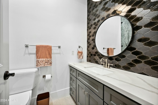 bathroom with vanity, tasteful backsplash, and toilet