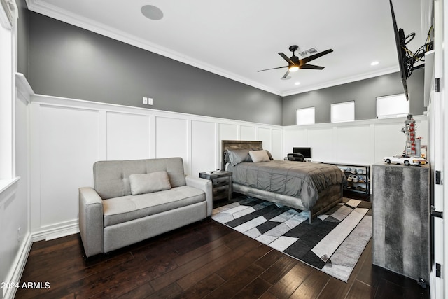 bedroom with ceiling fan, ornamental molding, dark wood-type flooring, and a towering ceiling