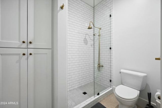 bathroom featuring tile patterned floors, a shower with shower door, and toilet