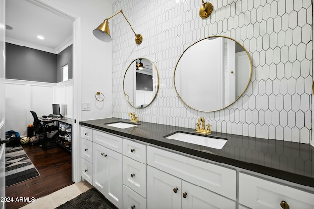 bathroom with backsplash, hardwood / wood-style floors, vanity, and ornamental molding