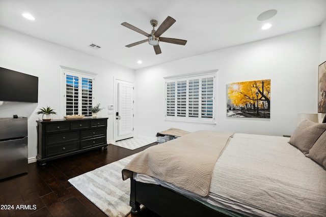 bedroom featuring ceiling fan, stainless steel fridge, and dark wood-type flooring