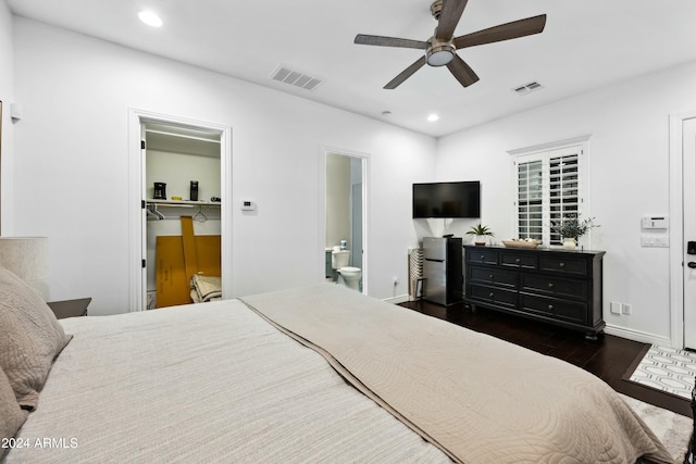 bedroom with ceiling fan, a spacious closet, dark hardwood / wood-style flooring, ensuite bathroom, and a closet