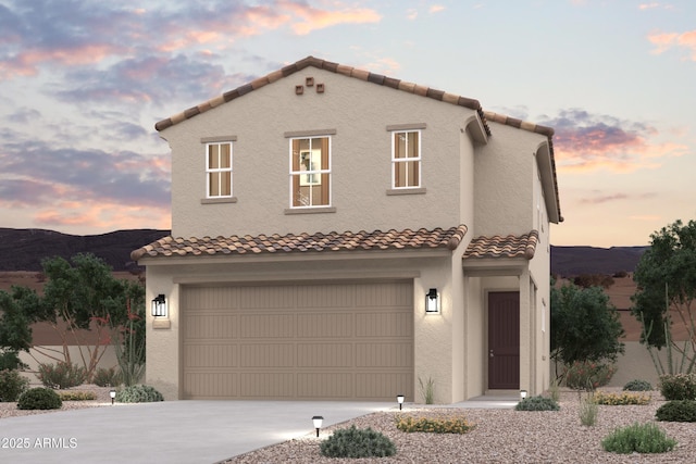 17356 W Jessie Ln, Surprise, AZ 85387 - mediterranean / spanish house with a tile roof, concrete driveway, an attached garage, a mountain view, and stucco siding