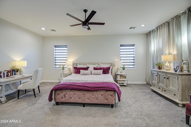 carpeted bedroom featuring multiple windows and ceiling fan