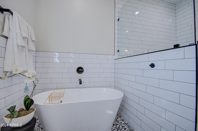 bathroom with a bath and tile walls