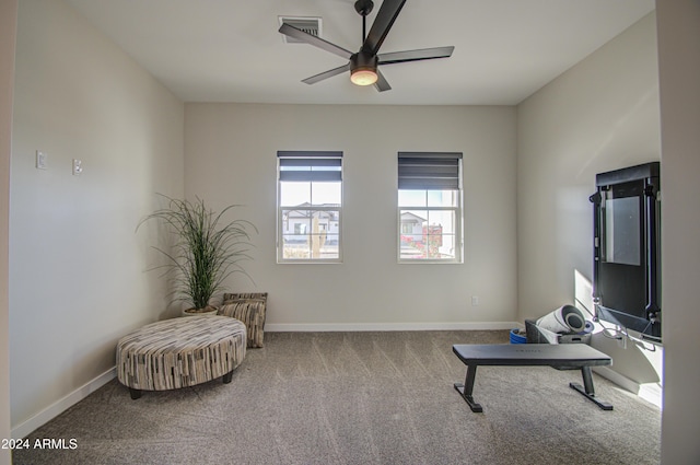 living area featuring carpet flooring and ceiling fan