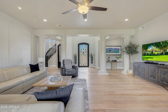 living area with visible vents, decorative columns, and light wood finished floors