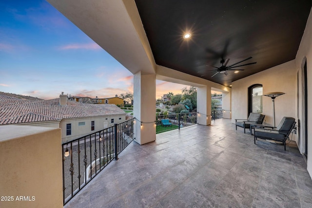 view of patio / terrace with a balcony and a ceiling fan