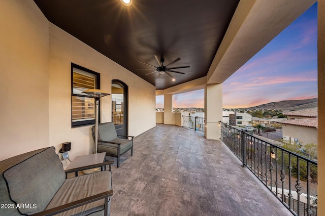 view of patio featuring a mountain view, a balcony, and a ceiling fan