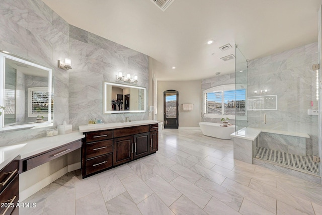 full bath featuring a freestanding tub, visible vents, vanity, tile walls, and a stall shower