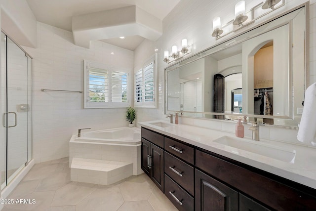 bathroom with a bath, a walk in closet, a sink, and tile patterned floors