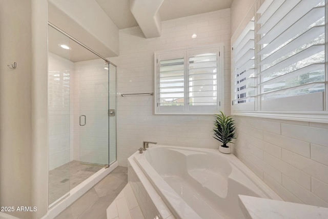 bathroom featuring a garden tub and a shower stall