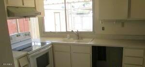 6029 N 31st Ave, Phoenix, AZ 85017 - kitchen with white electric range, under cabinet range hood, light countertops, and a sink