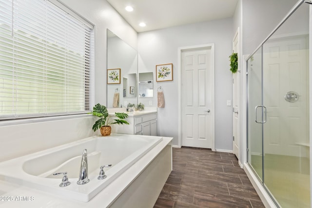 bathroom with vanity and shower with separate bathtub