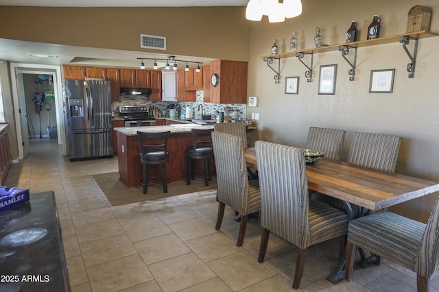 dining space with light tile patterned floors, vaulted ceiling, and sink