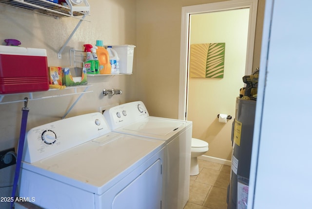 washroom featuring washer and clothes dryer, electric water heater, and light tile patterned flooring