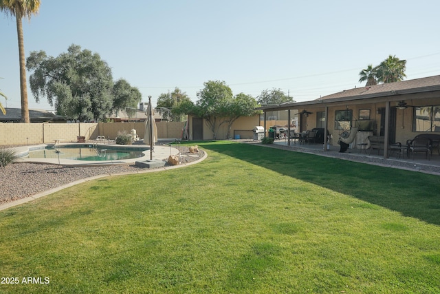 view of yard featuring ceiling fan, a fenced in pool, and a patio