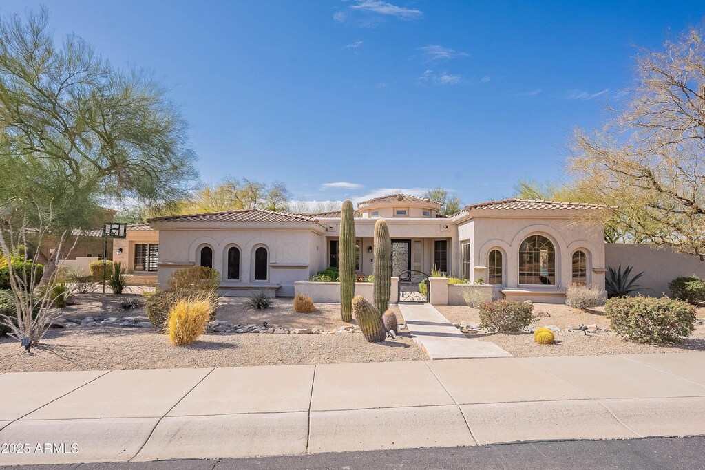 mediterranean / spanish home with a tile roof and stucco siding