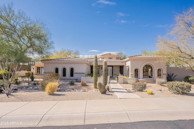 mediterranean / spanish home with a tile roof and stucco siding