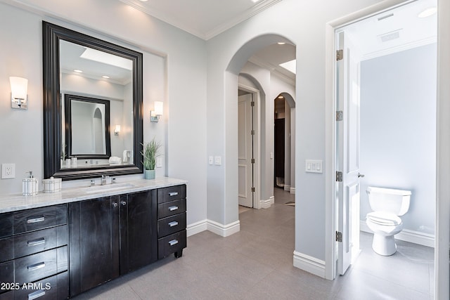 bathroom featuring baseboards, visible vents, toilet, ornamental molding, and vanity