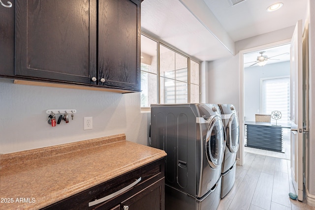 washroom with a wealth of natural light, washing machine and dryer, cabinet space, and ceiling fan