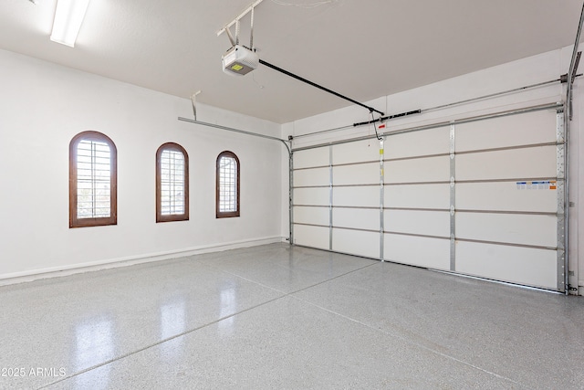 garage with a garage door opener and baseboards