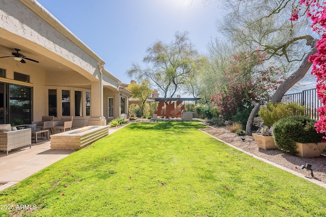 view of yard with an outdoor living space, a ceiling fan, and a patio